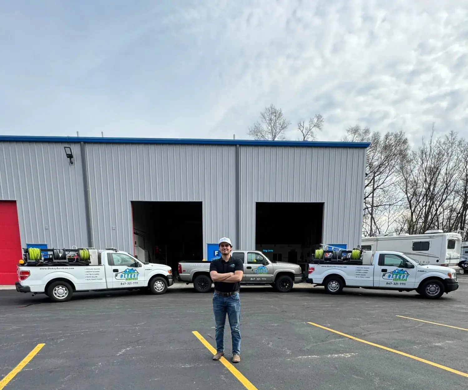 Oleksy Services owner standing in front of the company's fully equipped service fleet at its home facility