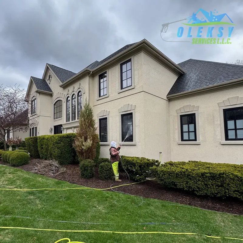 Crew soft washing a large home exterior